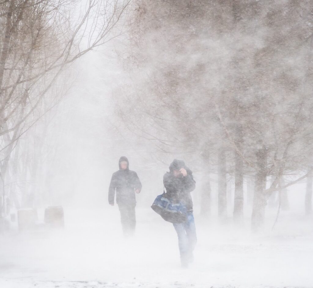 Two men walking in a snow storm